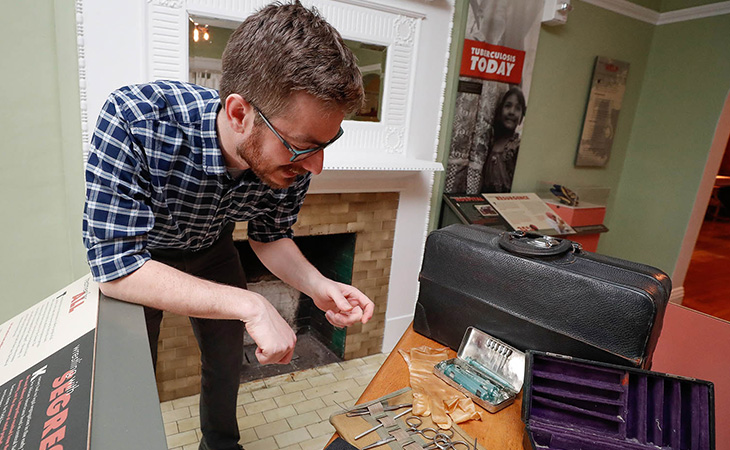 a faculty member shows off items at the Frank Museum